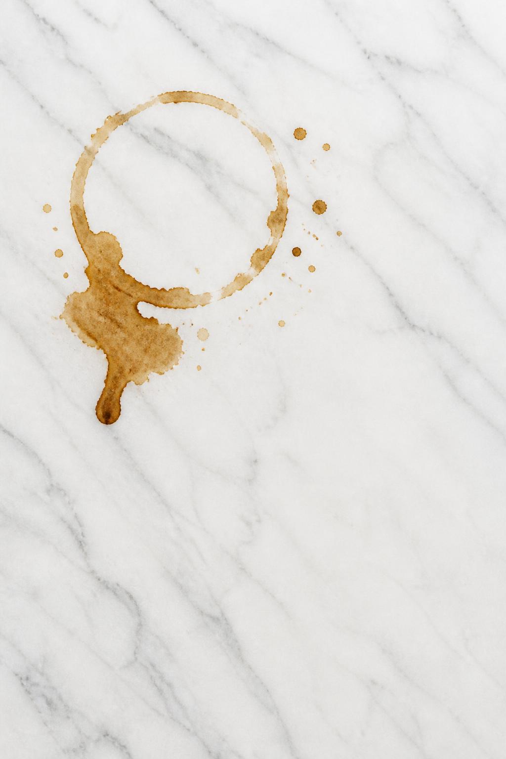 Clean white marble with a natural spilled coffee stain in the upper area